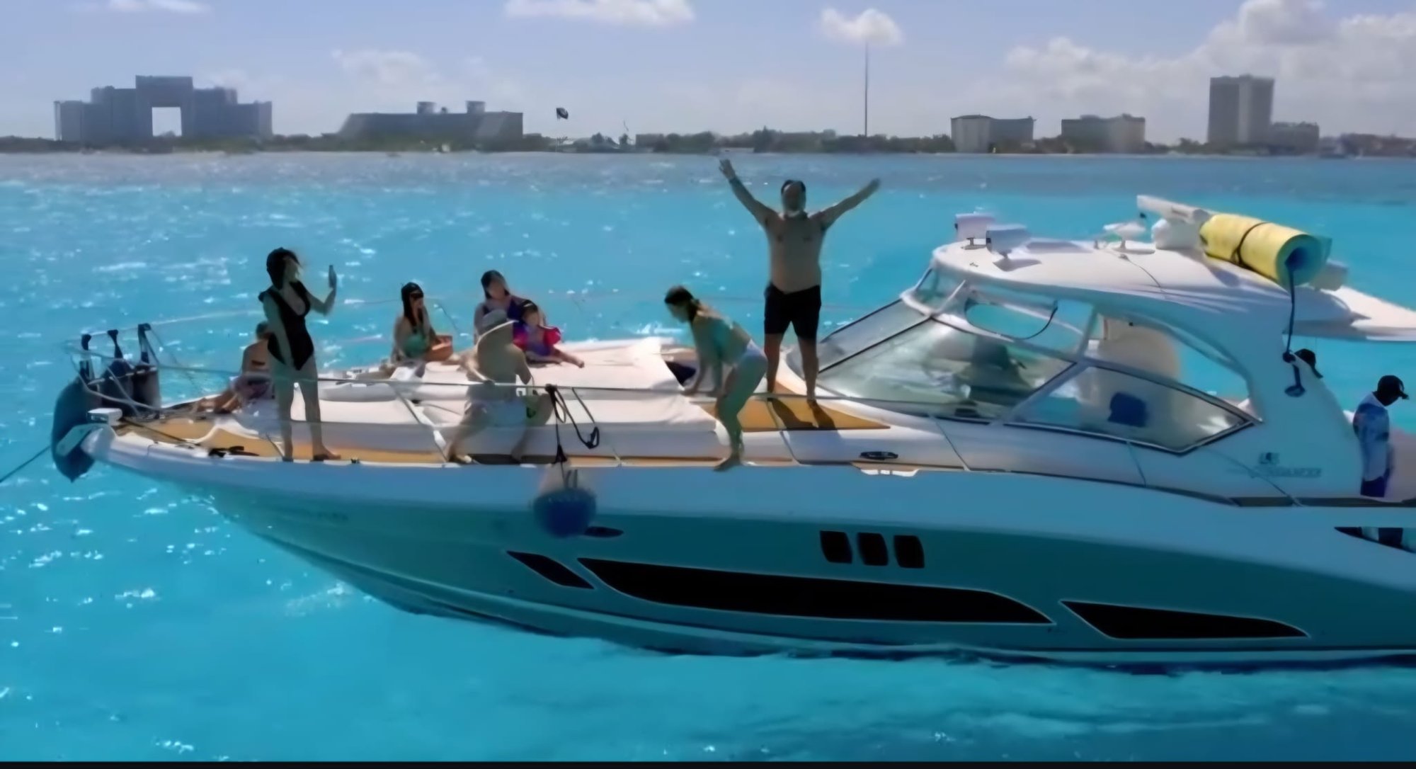 Guests jumping from private yacht charter Cancun turquoise water